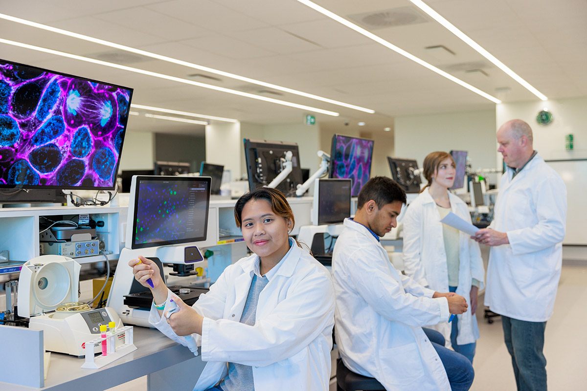 Students in white coats in lab environment