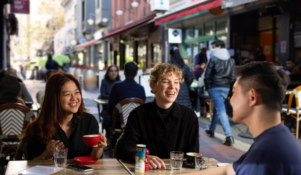 3 people have coffee at a cafe
