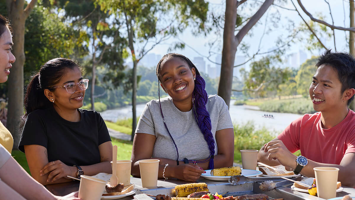 Students sharing a picnic by the river