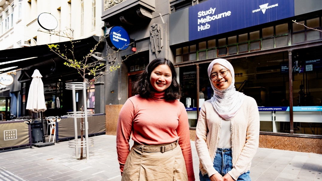 Two international students standing in Hardware Lane outside the Study Melbourne Hub, heritage building