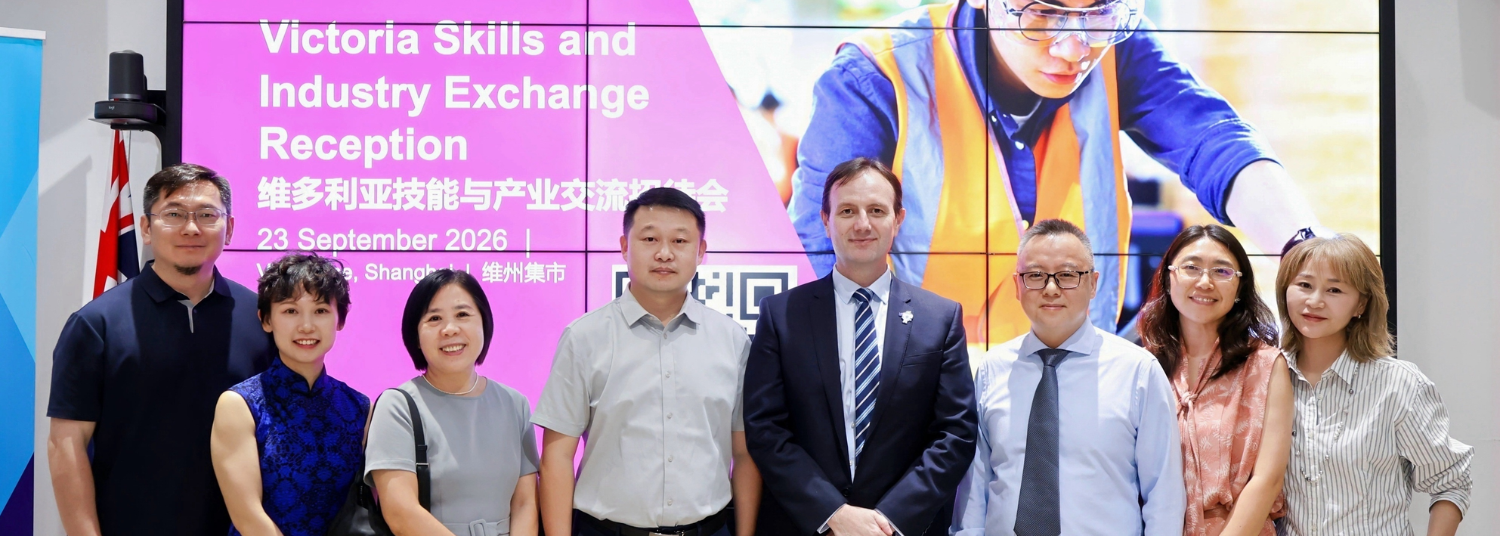 Group of people standing together at an event in front of a slide