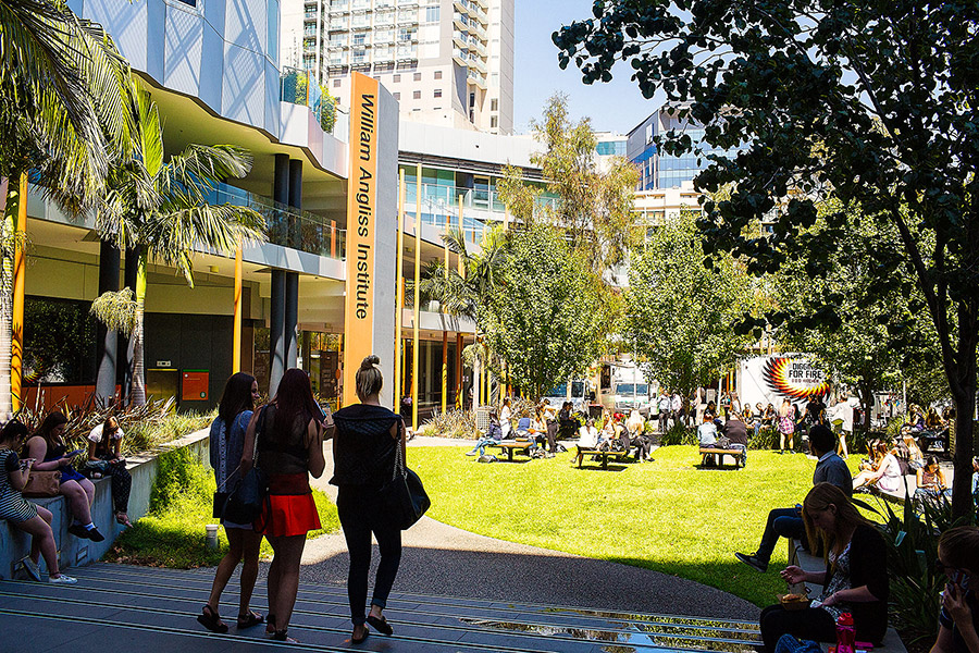 Students enjoying sunny grassed area at William Angliss TAFE