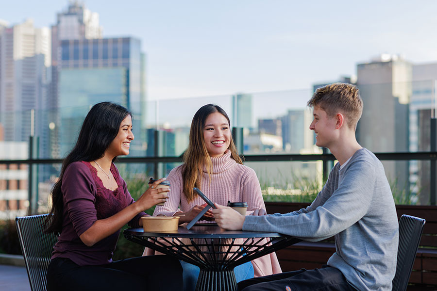 Students sitting at table with city skyline in the background