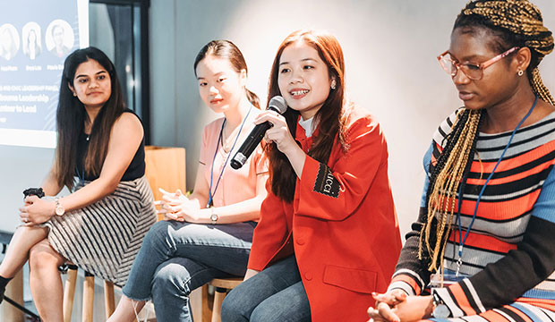 Four female students talking in a conference