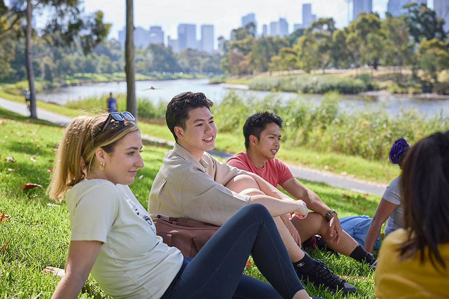 Students sitting by Yarra River