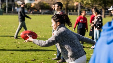 International student learning how to play Australian football