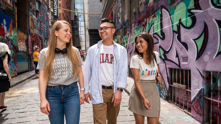 ACU students walking through laneway with graffiti artwork