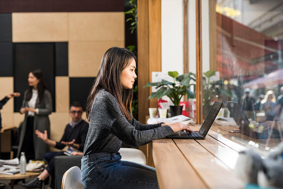 Woman working on laptop in cafe