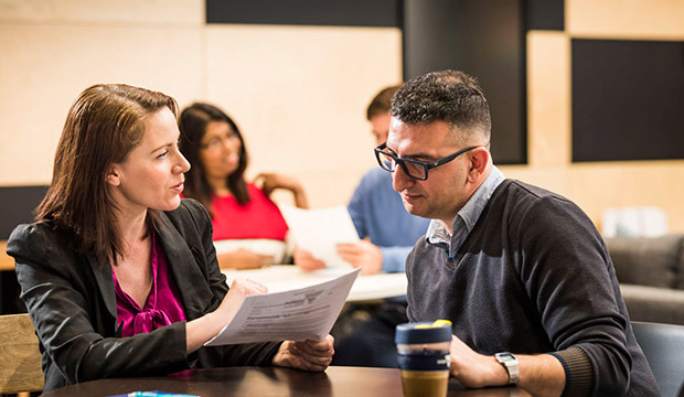 Two people sharing a coffee and reading report