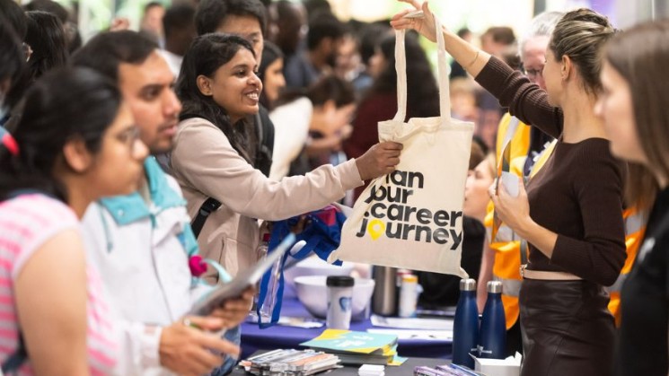 Employers handing out showbags to students at careers fair