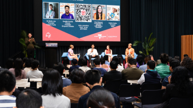 A group of people at a conference listening to a panel of speakers.