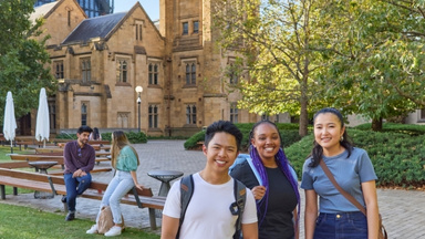 International students wearing backpacks, in the University of Melbourne grounds