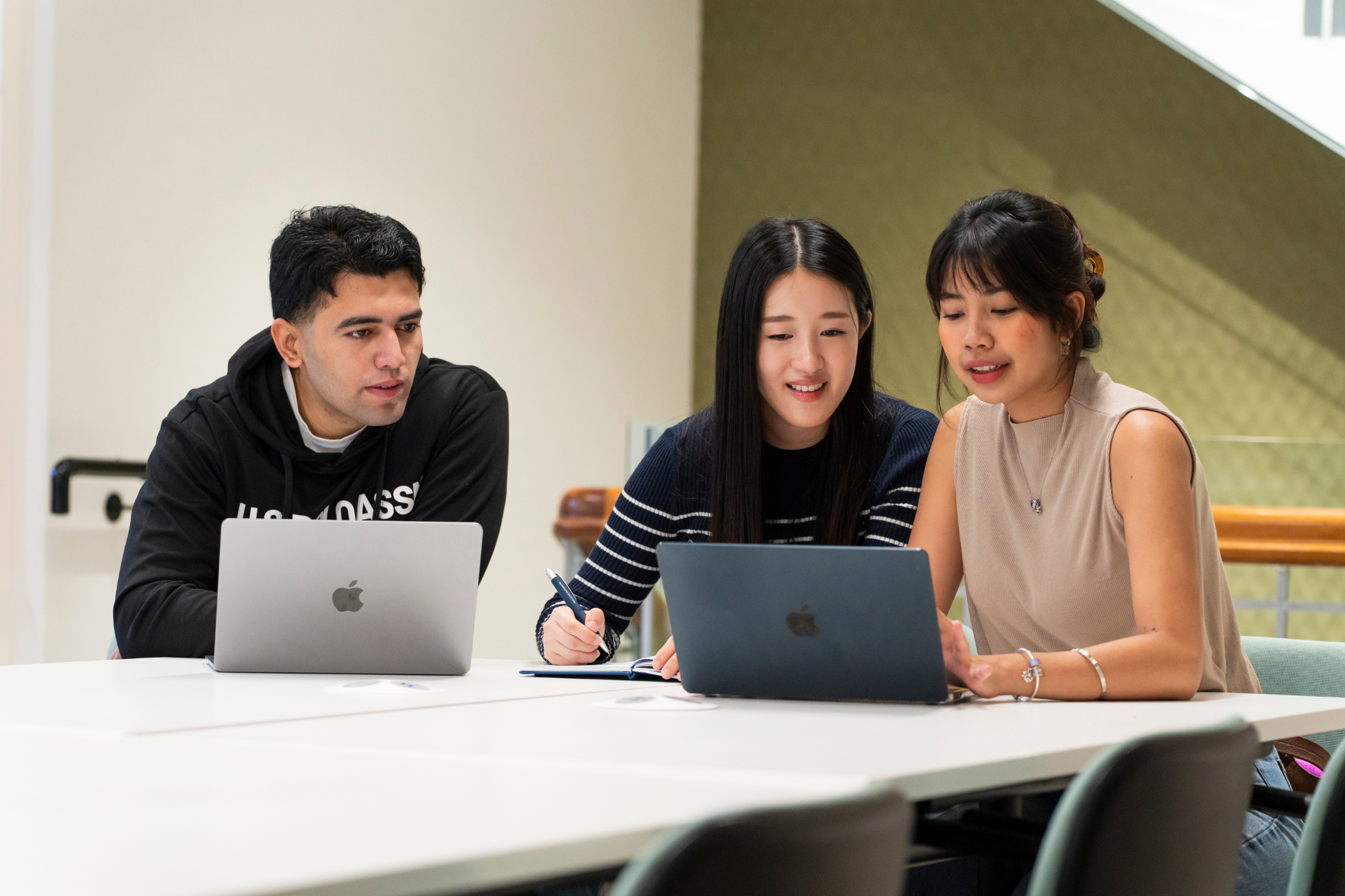 Three people working together using a laptop 