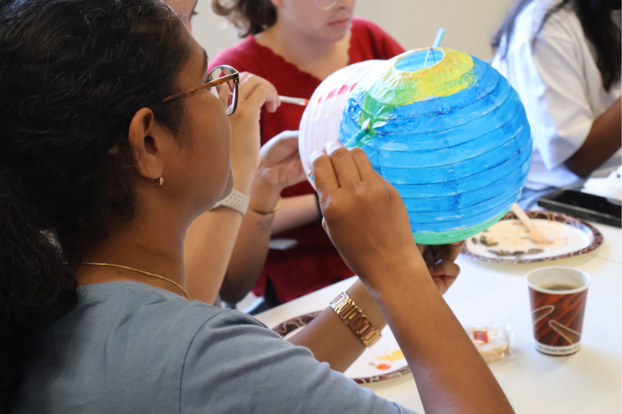 a student painting on a lantern