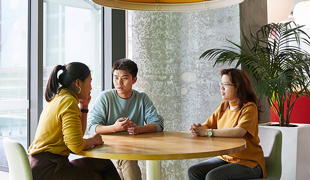 Three students sitting around a table