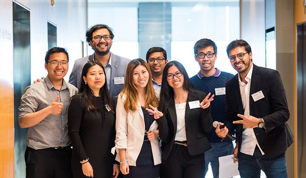 Eight students lined up smiling in corridor