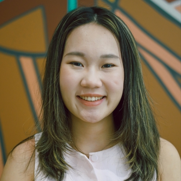 Head shot of Eva, aboriginal art in background