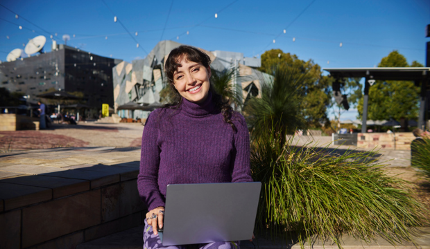 A person sitting outside with a laptop