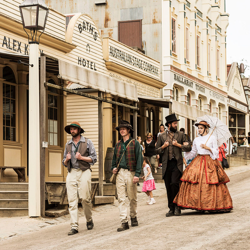 Two people walking through old town in period costume