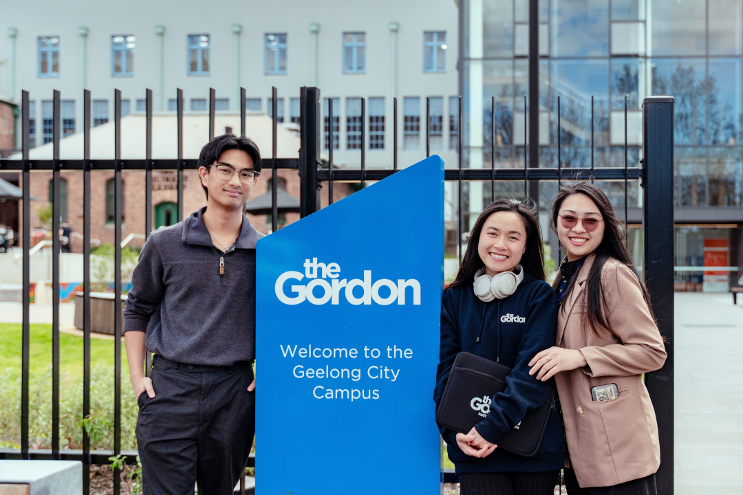 Three students posing in front of The Gordon 