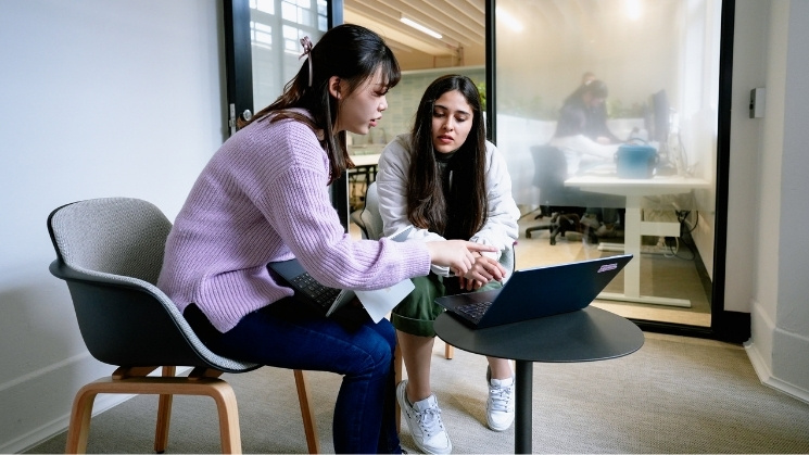 Students collaborating with a laptop at the Study Melbourne Hub