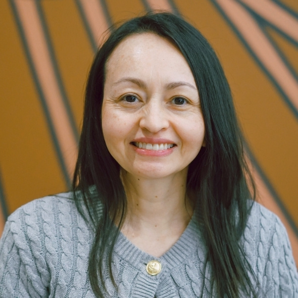 Head shot of Heidy, aboriginal art in background