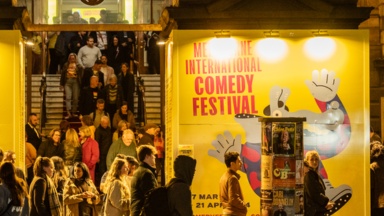 Melbourne International Comedy Festival branding at the Melbourne Town  Hall, people mingling and leaving a show