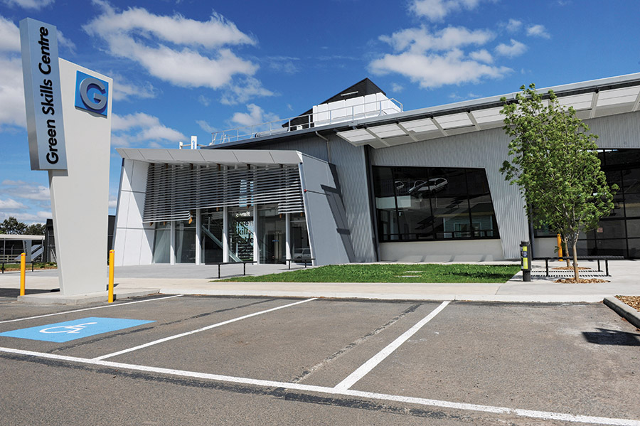 Accessible parking spot in carpark, Green Skills Centre logo on sign post building in background