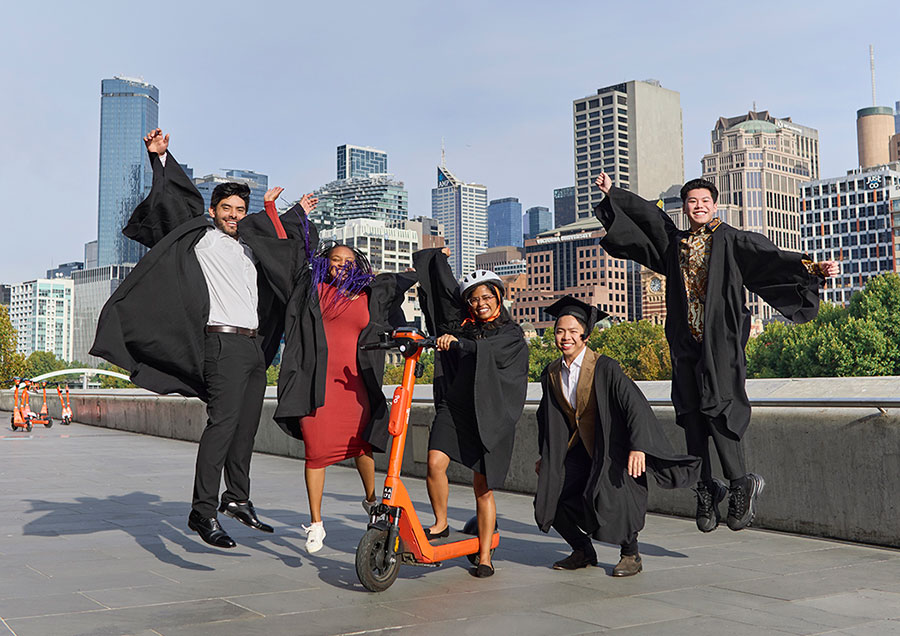 Students in gowns jumping