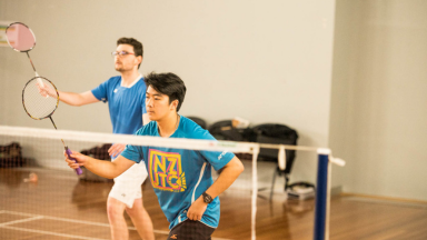 Two students playing badminton