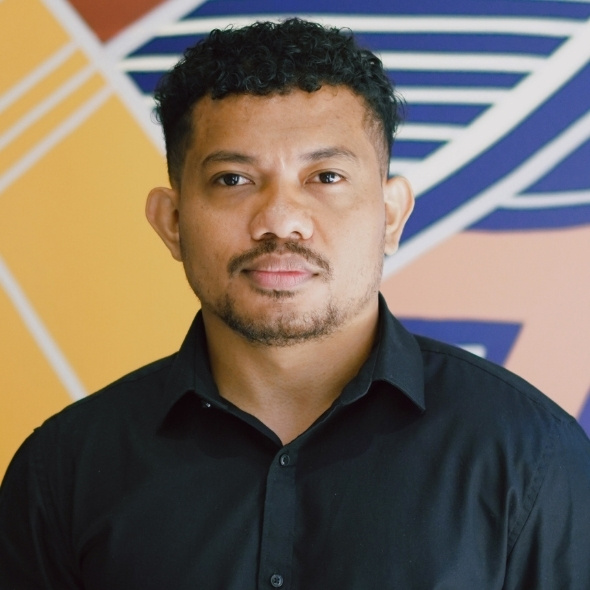 Head shot of Augusto, aboriginal art in background