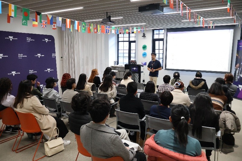 a group of people seated and watching a presenter speak