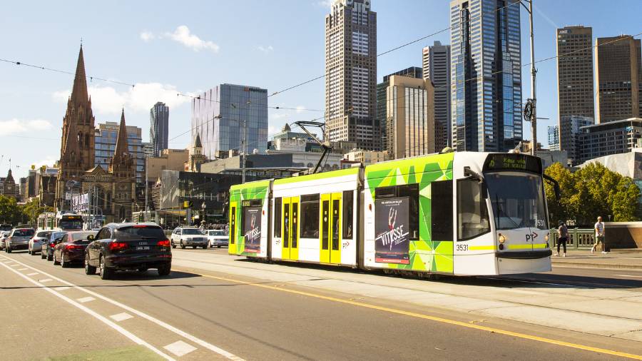 Driving down Swanston Street in Melbourne towards Flinders Street Station, tram in the middle of the road