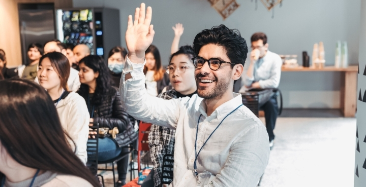 Student with hand up to speak at networking event