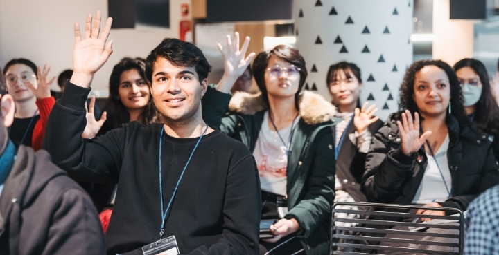 Students raising hands to speak at networking event