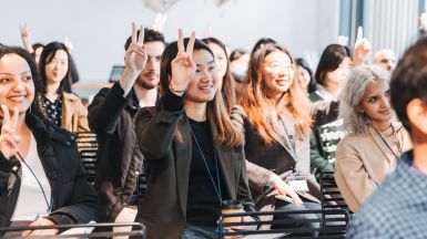 Students in theatre presentation making peace sign