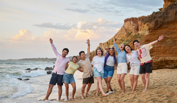 A group of people posing for a photo on a beach